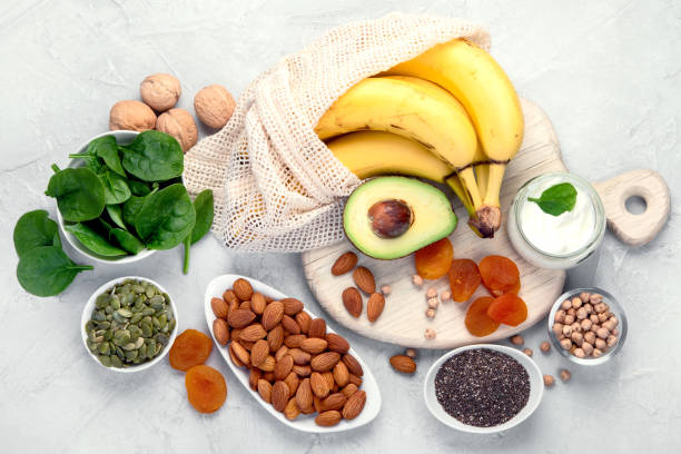 A selection of nutrient-rich foods including bananas, nuts, seeds, spinach, and yogurt, highlighting essential vitamins and minerals.