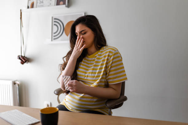 A woman feeling unwell due to overhydration, holding a glass of water and experiencing discomfort.