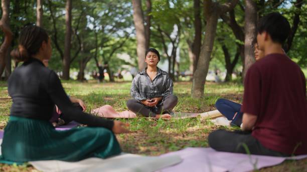 A group of people practicing mindfulness meditation in a peaceful outdoor setting, focusing on relaxation and stress relief.