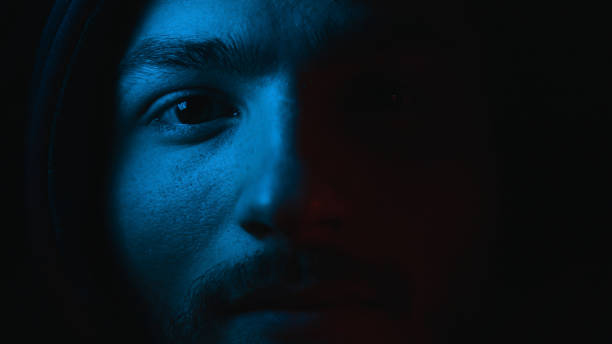 A close-up of a man's face illuminated by blue light, highlighting how blue light affects your skin and its potential impact on skin health and aging.