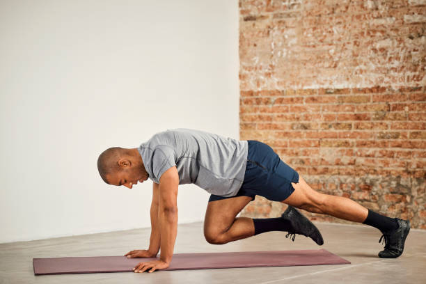 A man performing mountain climbers on a mat, activating his core and lower body for a dynamic workout.