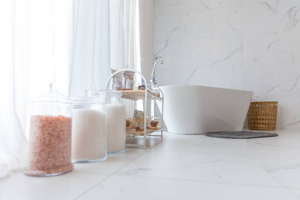A modern bathroom with jars of Epsom salt and bath essentials, promoting the benefits of an Epsom Salt Bath for Muscle Recovery.