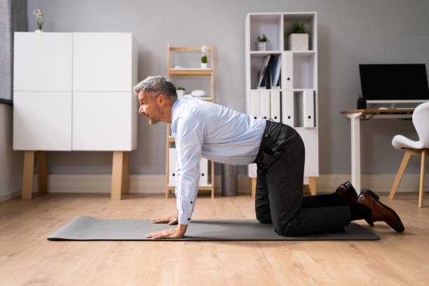 A man performing Cat-Cow yoga pose on mat, arching and rounding their spines, enhancing spinal mobility and relieving back pain.