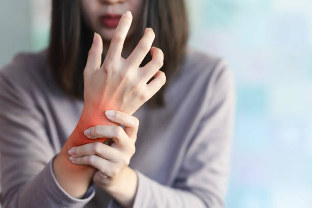 A woman holding her wrist in discomfort, experiencing arthritis pain and seeking natural pain management solutions.