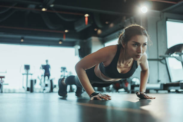 Woman performing a push-up in a gym, showcasing the effectiveness of bodyweight exercises for strength and endurance.