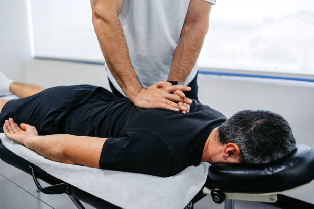 Chiropractor performing a back massage to relieve chronic pain.