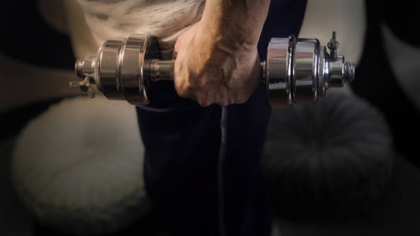 A close-up of a strong hand gripping a heavy metal dumbbell, emphasizing forearm muscles and grip strength, essential for improving overall fitness performance. representing improve your stamina.
