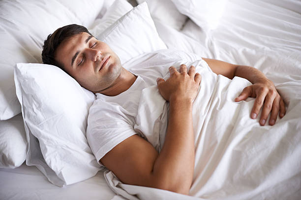 A man sleeping peacefully in bed, emphasizing the importance of quality sleep to naturally improve insulin sensitivity.