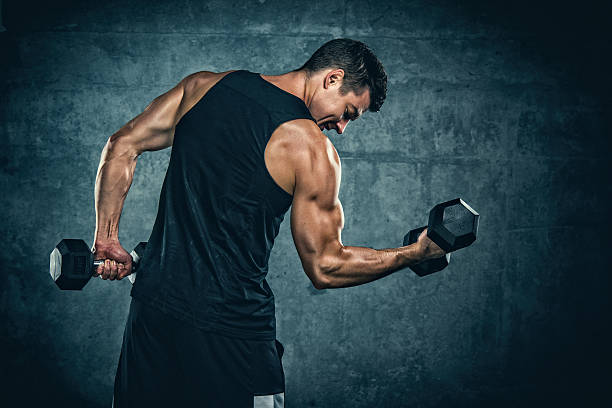 Strength training vs. cardio for weight loss – man performing dumbbell curls, showcasing muscle engagement.
