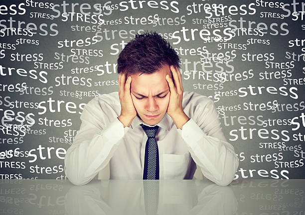 A stressed businessman holding his head, highlighting the importance of managing stress effectively to naturally improve insulin sensitivity.